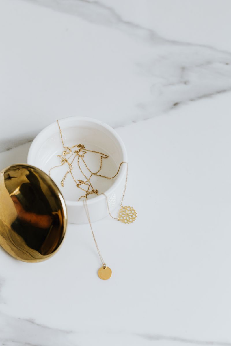 Gold rings and necklaces resting on marble